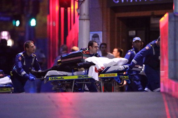 Ambulance officers move into the Lindt Chocolat Cafe in Martin Place following the shooting.