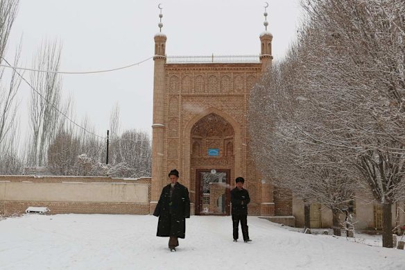 Uyghur men walking out of a mosque in a village in Ujme township, Akto County.