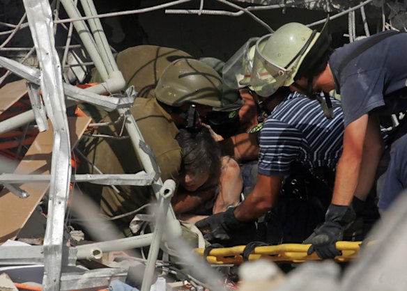 Rescue workers pull out of the rubble an earthquake survivor in Concepcion, southern Chile.
