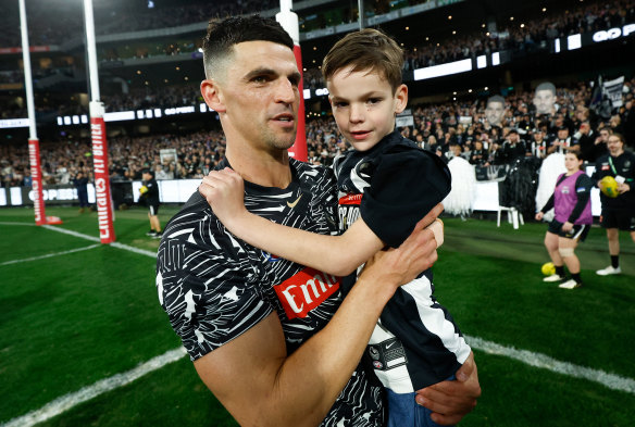 30-something: Scott Pendlebury, pictured with son Jax, is one of several veteran Magpies chasing another premiership.