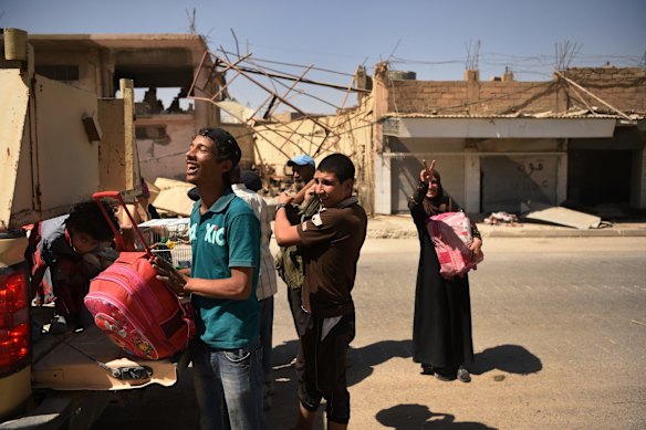 Families arrive safely at a screening point after being rescued by Iraqi forces.