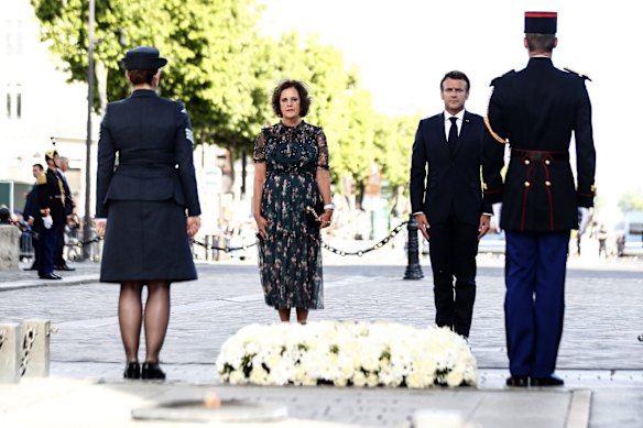 French President Emmanuel Macron and British Ambassador to France Dame Menna Rawlings, second left, stand at attention under the Arc de Triomphe to mark the Platinum Jubilee .