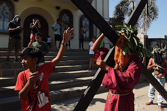 The Catholic custom of atoning for their sins, a man carries out the decades long tradition of carrying a cross through the streets of Barangay San Pedro Cutud in Pampanga north of Manila.
