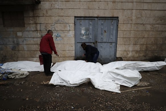 Men try to identify the bodies of earthquake victims recovered outside a hospital, in Aleppo, Syria.