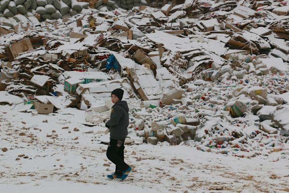 Uighur boy walks past a recycling ground in Kashgar's old town.