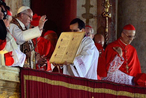 Newly elected Pope Francis I appears on the central balcony of St Peter's Basilica.