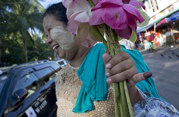 A flower seller points her finger marked with indelible ink, a day after casting her vote in Yangon, Myanmar.