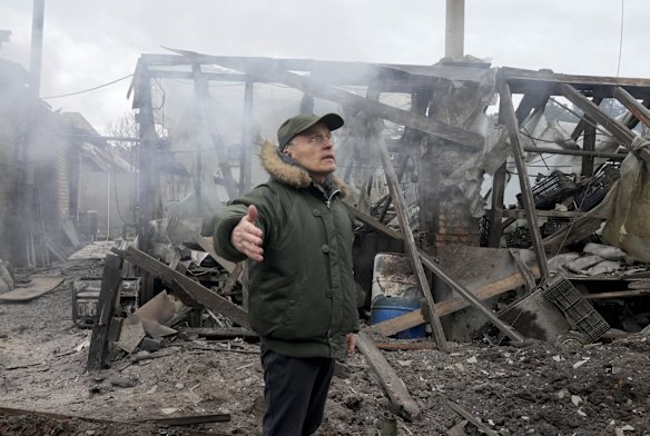 A man surveys the ruins of a house destroyed by Russian artillery shelling, in the village of Horenka.