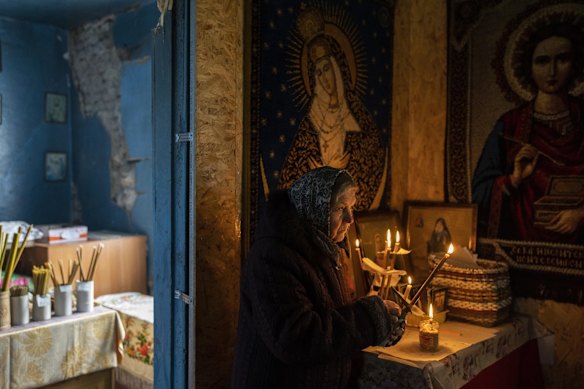 A woman takes part in a Good Friday ceremony inside the damaged Pokrova church, during Orthodox Easter, on the outskirts of Chernihiv.