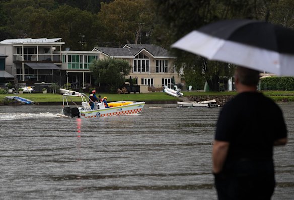 An SES boat cruises along the Woronora River in Woronora, Sydney. The area has been issued with a flood evacuation order.