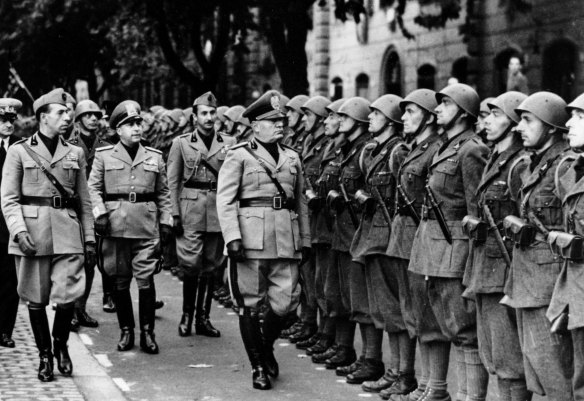 Italian Premier Benito Mussolini, right, and members of his staff review troops of the newly formed Fascist battalions on the outskirts of Rome, Italy on October 19, 1941.