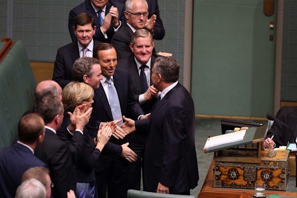 Prime Minister Tony Abbott congratulates Treasurer Joe Hockey after he delivered his first budget.
