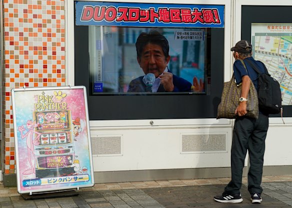 A man watches stops to watch the news in Tokyo, Japan.