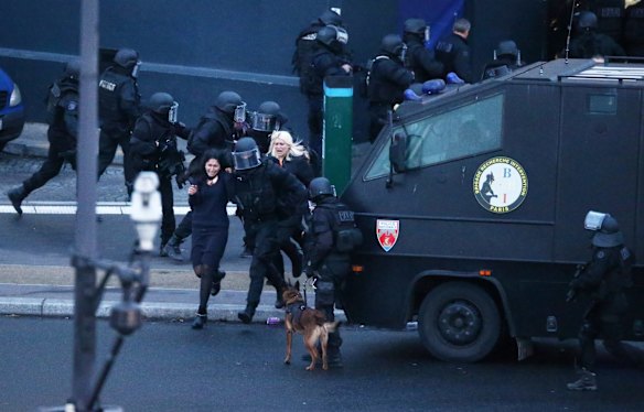 Hostages run to safety as police storm the grocery store. 