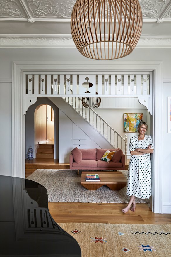 Fretwork decorates the opening between the reception and living rooms. The “Octo 4240” pendant light is by Secto Design and the artwork is by Deborah Moss.