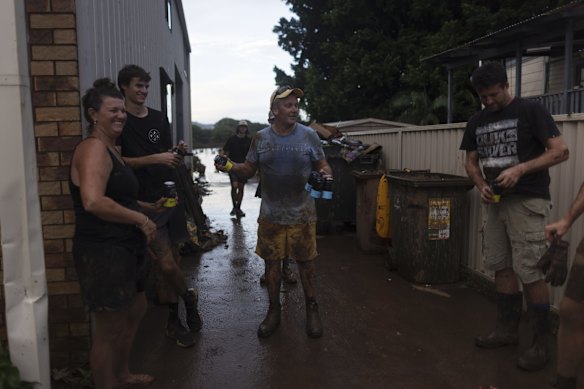 Friends share a beer after helping clean up a business in Lismore. 