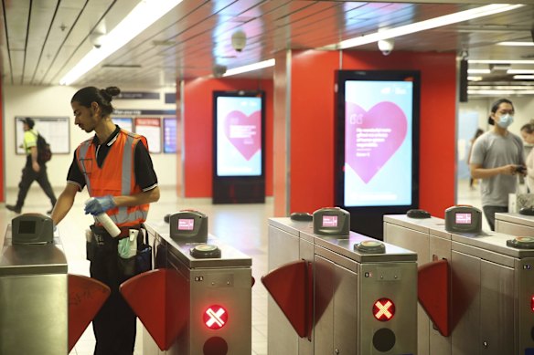 A State Rail employee cleans surfaces at Central Station as more commuters begin to use public transportation with the easing of social restrictions by the State Government.