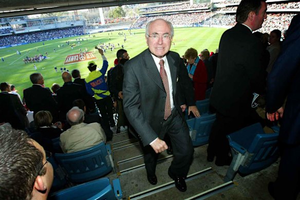 John Howard leaves the 2004 AFL grand final at three quarter time.