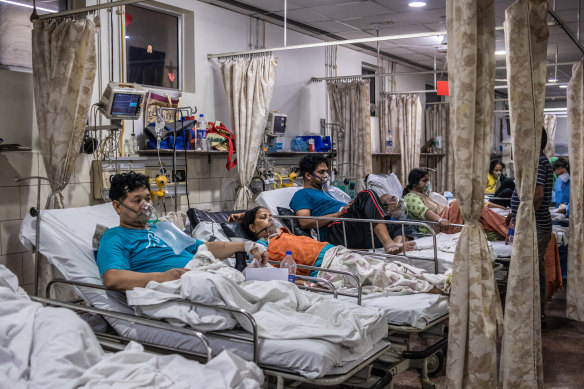 Patients who contracted the coronavirus lie in beds while connected to oxygen supplies in a  hospital in New Delhi.