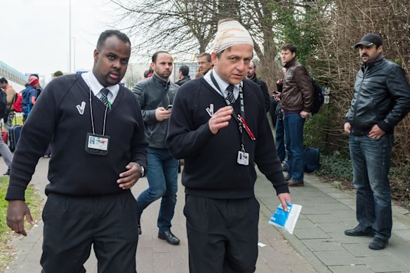 An injured man gestures outsude Brussels airport after explosions rocked the facility in Brussels, Belgium.