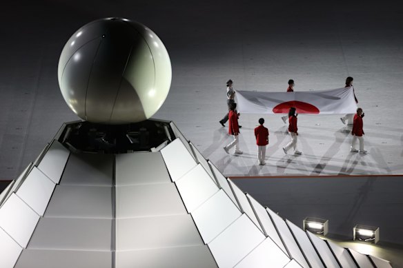 The Japanese flag is carried past the Olympic cauldron during the Opening Ceremony of the Tokyo 2020 Olympic Games at Olympic Stadium on July 23, 2021 in Tokyo, Japan.