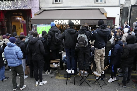 People crowd around a TV at a bar to watch the game in Paris.