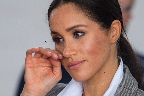 Meghan, Duchess of Sussex swats away a fly as she attends the naming and unveiling of a new Royal Flying Doctor Service aircraft.