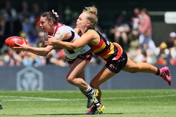 Helping hand: Alice Burke looks to handball while tackled by Zoe Prowse.