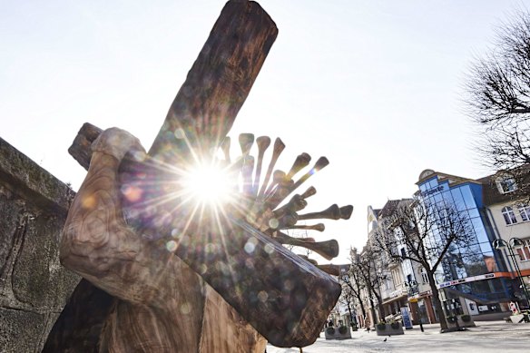 A sculpture of Jesus Christ wearing a crown in the shape of a coronavirus by Robert Wyskiel stands in front of the St George church during the coronavirus pandemic in Sopot, northern Poland.