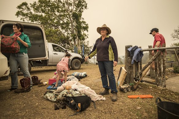 Dungay cattle farmers Lisa Lincoln with Alice Lincoln and grandmother Sue Clarke, pack their vehicle ahead of worsening bushfire conditions.