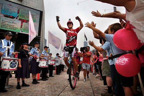Samuel Johnson celebrates  crossing the finish line after his year-long Love Your Sister unicycle trek.