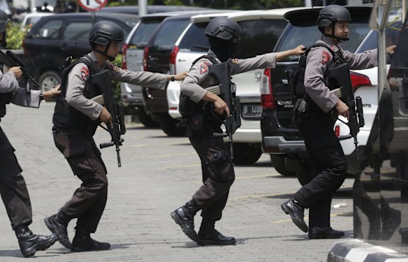Police officers take their position near the site where an explosion went off in Jakarta, Indonesia Thursday, Jan. 14, 2016. Suicide bombers exploded themselves in downtown Jakarta on Thursday while gunmen attacked a police post nearby, a witness told The Associated Press.