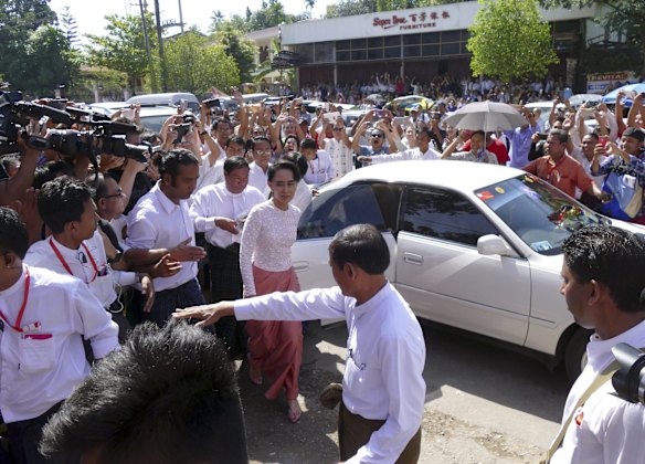 Myanmar opposition leader Aung San Suu Kyi, center, is welcomed by supporters upon arrival at the headquarters of her National League for Democracy party in Yangon, Myanmar.
