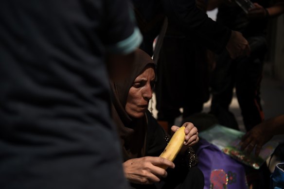 A woman eats her first piece of fruit in over six months after arriving safely at a screening point after being rescued by Iraqi forces.