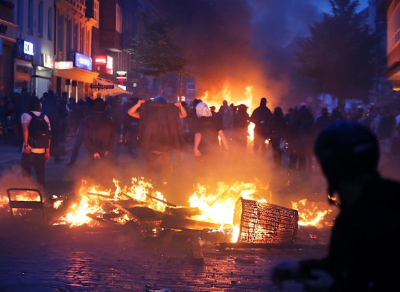 Protesters stay between fires on a street during a protest against the G-20 summit in Hamburg, northern Germany.