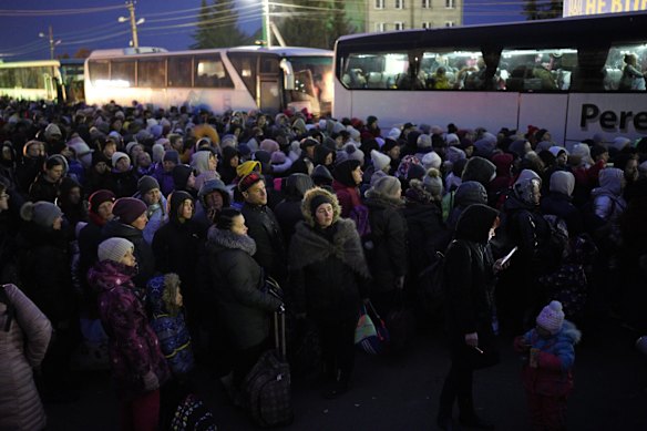 Refugees fleeing the war in Ukraine form a line as they approach the border with Poland in Shehyni, Ukraine.
