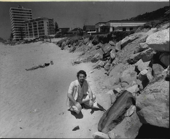 The member for Wakehurst, Mr Tom Webster, inspecting erosion on Collaroy Beach. In the background is one of several high-rise apartment blocks threatened by the erosion. November 14, 1980. 
