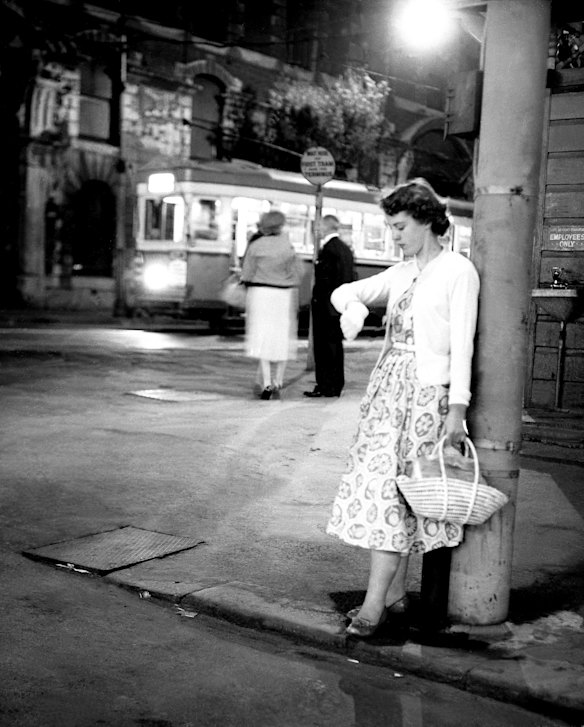 A woman waits for her tram home in 1958. 