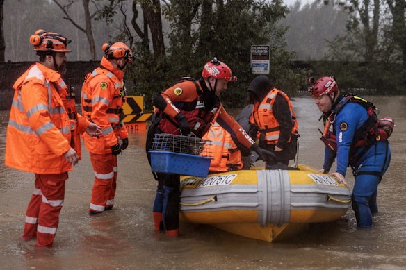 Lansvale residents Jack and Jamarcus, along with their pets, are evacuated by the NSW SES Kogarah Unit as the flood rises along the Georges River.