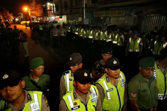 Indonesian riot squad police cordon off the street moments before the Bali Nine duo Andrew Chan and Myuran Sukumaran are transferred.
