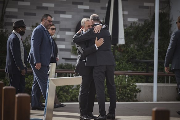 Poker champion Joe Hachem is embraced outside a private memorial for Shane Warne.
