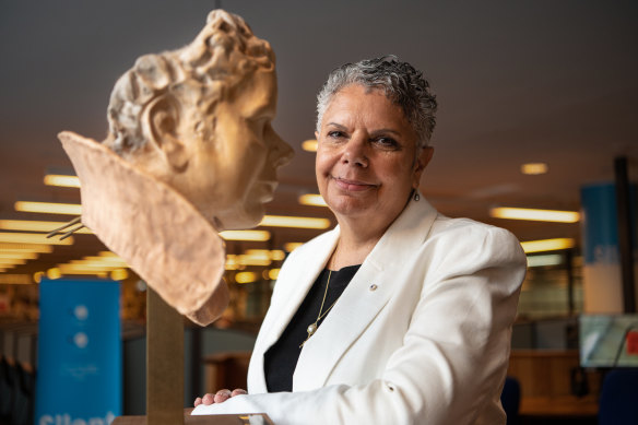 Deborah Cheetham Fraillon  with a sculpture of herself made by Anna-Wili Highfield in the Conservatorium library.