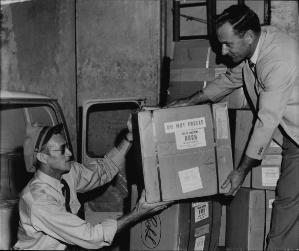 Jim Pate, of Kingsford (air flight driver for Ansett-A.N.A.) delivers the new quadruple antigen for immunization against whooping cough, tetanus, diphtheria and polio to the Commonwealth Health Department, city.
He rushed it from Mascot. Taking delivery (right) is Mr. M. Morrison, of Ryde, a senior clerk of the public vaccination campaign.
It was packed in ice for its trip from Melbourne. The first injections will be given tomorrow. February 22, 1961. 