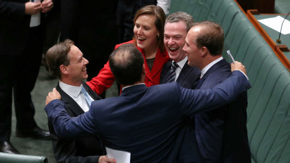Then federal environment minister Greg Hunt is congratulated by colleagues after carbon tax repeal bills passed the lower House in 2014. Lowy’s poll indicates support for the return of some form of price on greenhouse gas pollution.
