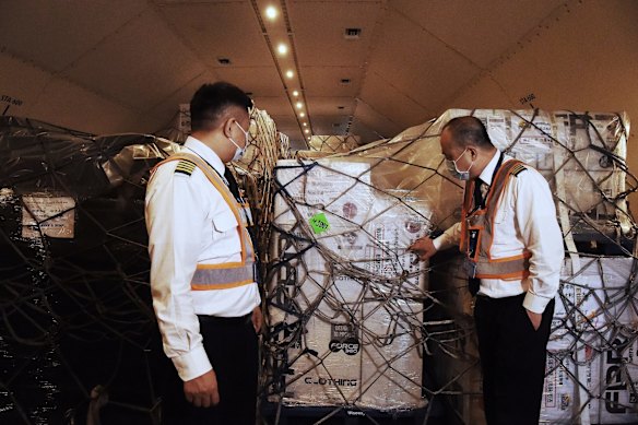 Pilots Yao Wang (left) and Zhili Luo (right) stand in the cargo hold amongst tonnes of freight consisting of medical equipment, protective clothing, infant formula, milk powder and disinfectant loaded onto a China Southern Cargo plane bound for Wuhan in China. February 23, 2020