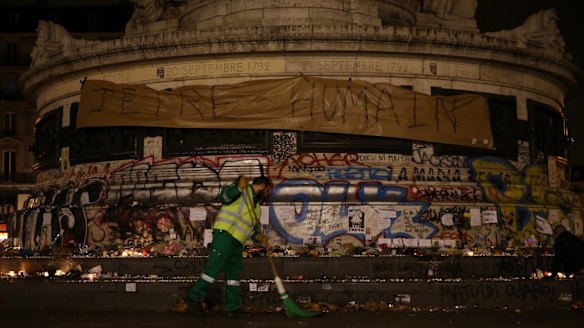 Street cleaners at the Place de la Republique where a memorial honouring 129 people killed by terrorists grows in Paris, France.