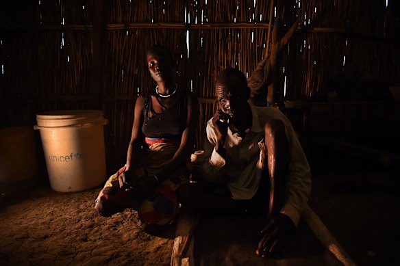 James Tut, 64, who became blind in 2005 sits with his daughter in a church inside the UN Bentiu Protection of Civilians (POC) site, Bentiu, Unity State, South Sudan. James Tut was forced to flee the fighting in Leer and two of his daughters were taken by force and he doesn't know where they are. 