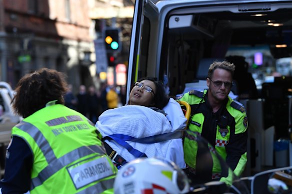 A woman is put into an ambulance outside Hotel CBD at the corner of King and York streets in Sydney.