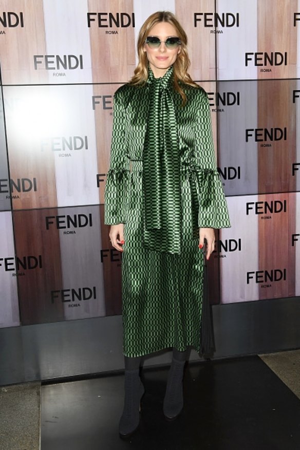 Olivia Palermo wore a silky green and black patterned dress with a high neck and bell sleeves at Fendi. 