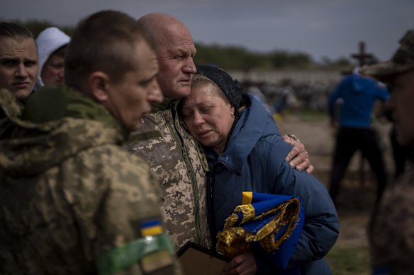 Irina Tromsa, 55, is comforted by comrades of her son Bogdan, 24, during his funeral at the cemetery in Bucha, on the outskirts of Kyiv. The Ukrainian paratrooper was killed during fighting against Russian troops in the north-east of the country.